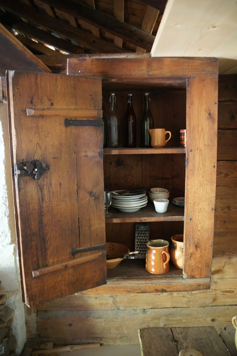 Placard de cuisine en bois contenant de la vaisselle.